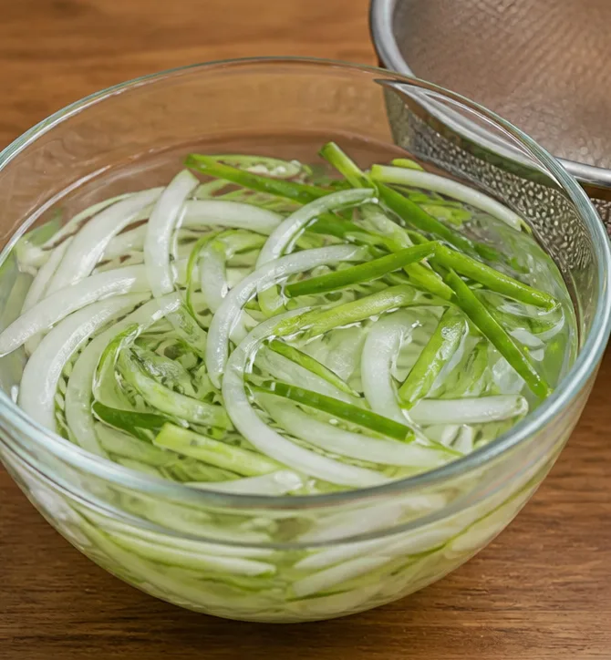 골뱅이 무침 | 비빔면 기본 소스으로 맛있게 만드는 법 조리 단계 2 이미지 - 채 썬 양파와 대파를 찬물에 5분간 담갔다가 체에 밭쳐 물기를 빼줍니다.