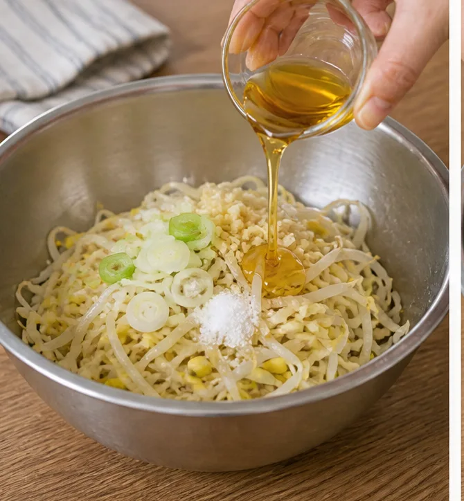 콩나물무침 레시피 | 아삭한 식감 살리는 데친 콩나물 조리 단계 5 이미지 - 물기 뺀 콩나물에 소금 1/2작은술, 다진 마늘 1쪽, 송송 썬 대파 1