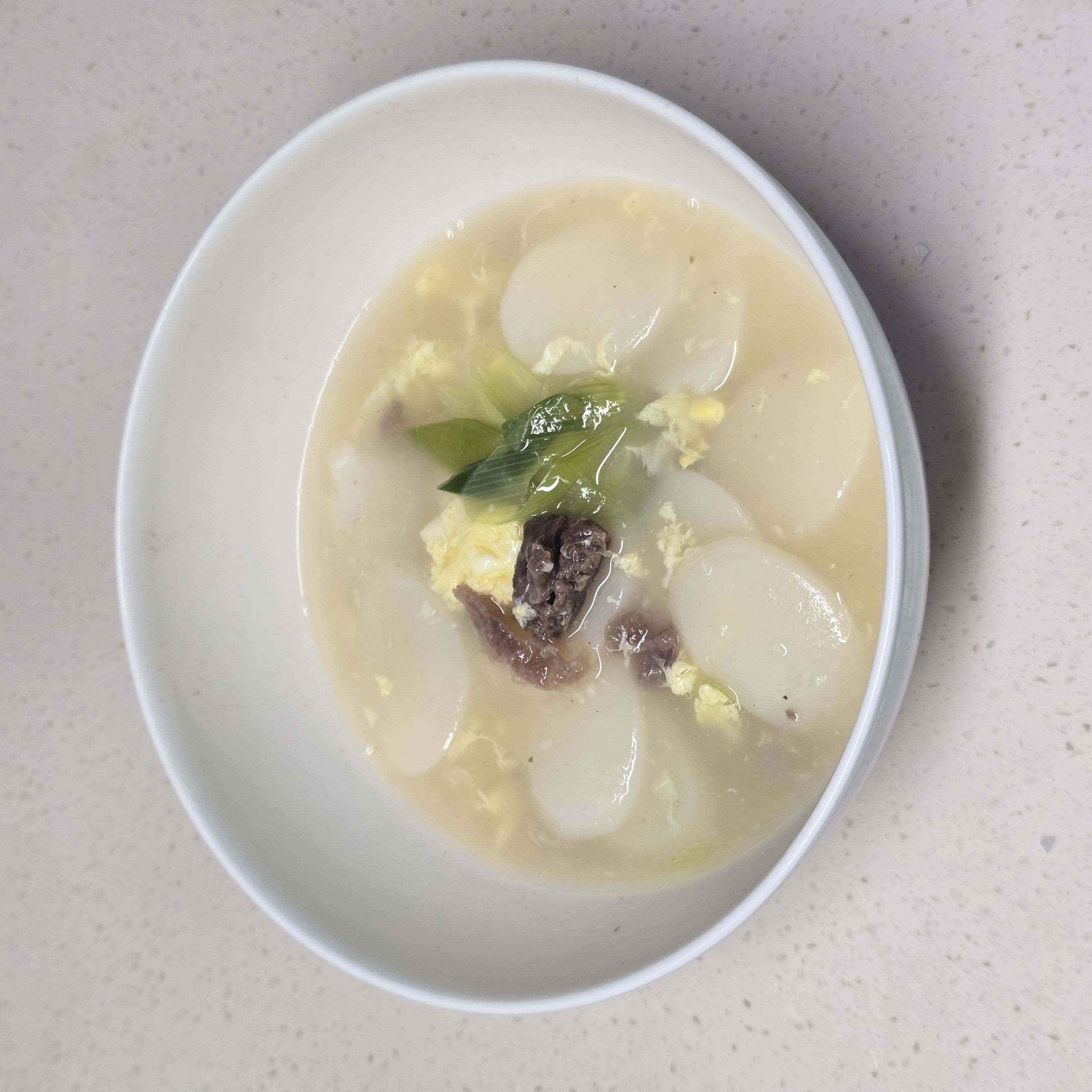 소고기 떡국 레시피 | 담백하고 깊은 국물, 집에서 쉽게 완성 조리 단계 6 이미지 - 부족한 간은 소금으로 조절한 뒤 그릇에 담아 마무리합니다.