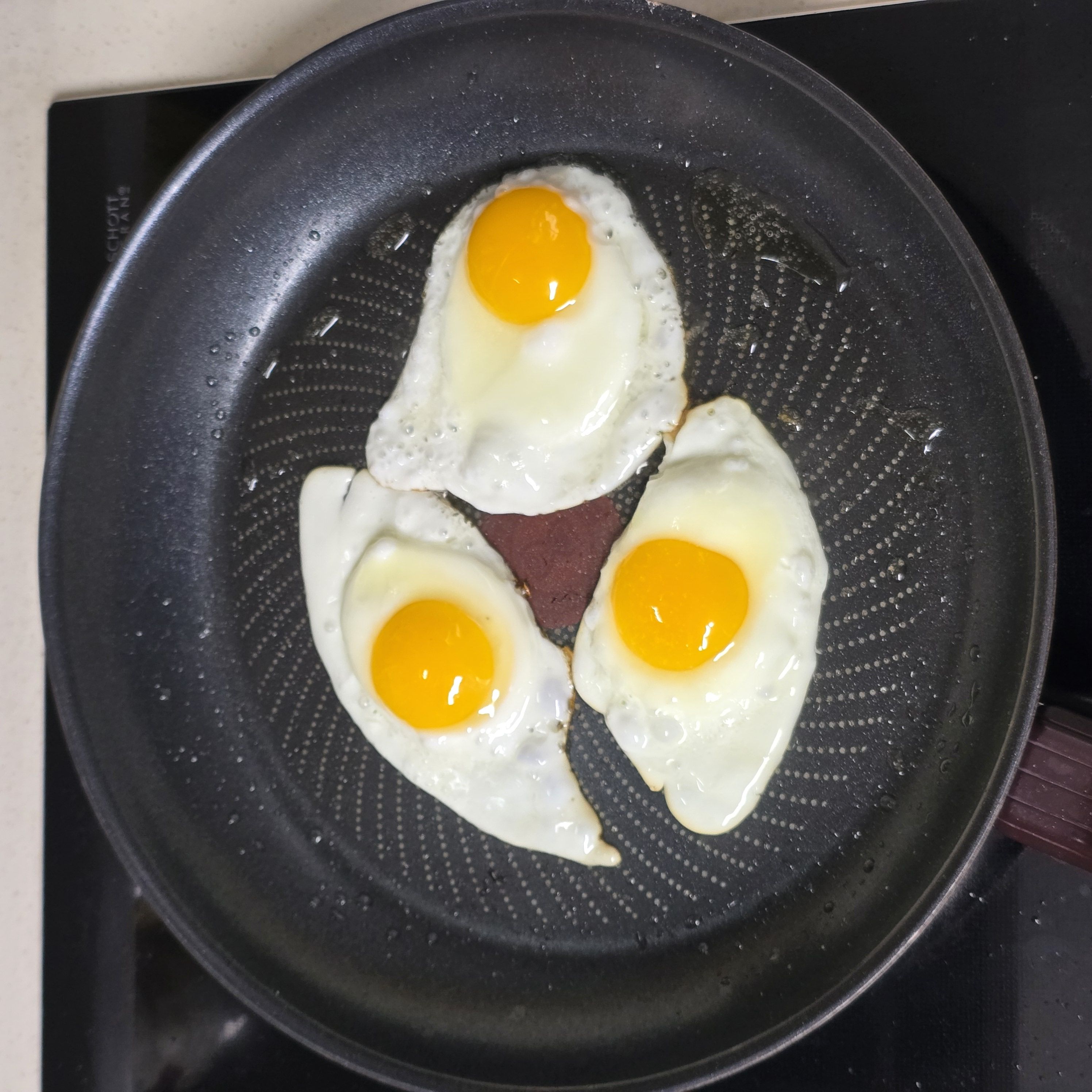 스팸 김치 볶음밥 | 실패 없는 식당에서 먹던 맛 (3인분) 조리 단계 1 이미지 - 팬에 기름을 살짝 두르고 계란을 하나씩 깨서 반숙 계란후라이를 만들어 둡
